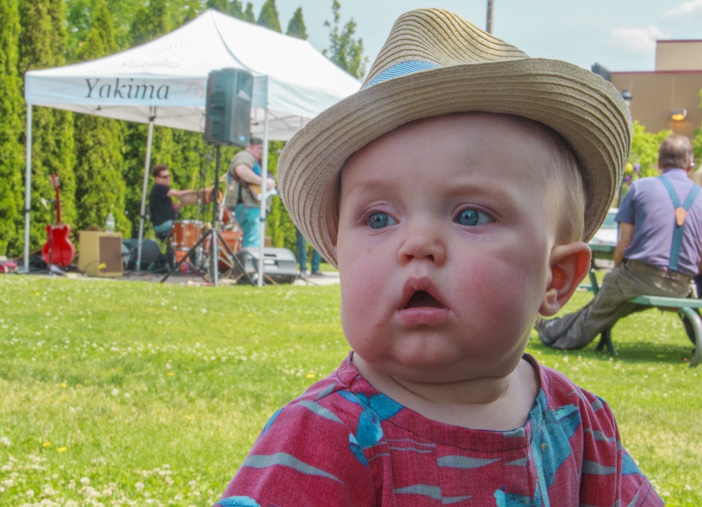 Future blues fan Dane Busseau listens to the cool sounds of The Vaughn Jensen Band at the Lunchtime Live! concert series kick-off in Downtown Yakima.  