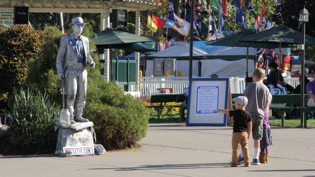 Three young fans can’t quite figure out what to think of  “Mr. Statue” performing near the Gazebo at the Central Washington State Fair.