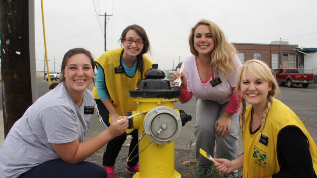 Missionary sisters Atkinson, Maez, Van Orden and Fox from Yakima’s LDS Church help paint fire hydrants around Yakima as service to the community.