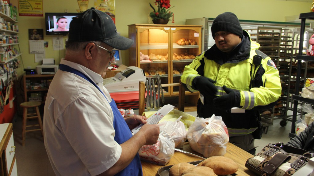 Parking Enforcement Officer Luis Torrico hands out and explains Snow Alert and Snow Route information to a local panaderia in Downtown Yakima with winter weather forecasted for Yakima.