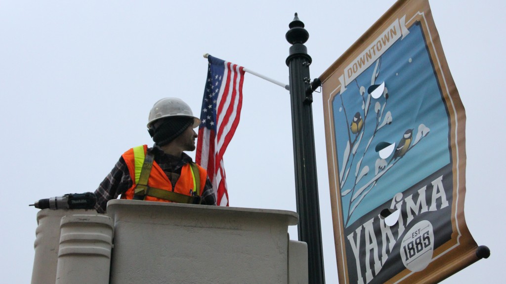 City Signal Technician Mike Calhoun hangs Yakima’s winter themed banners along Yakima Avenue.  