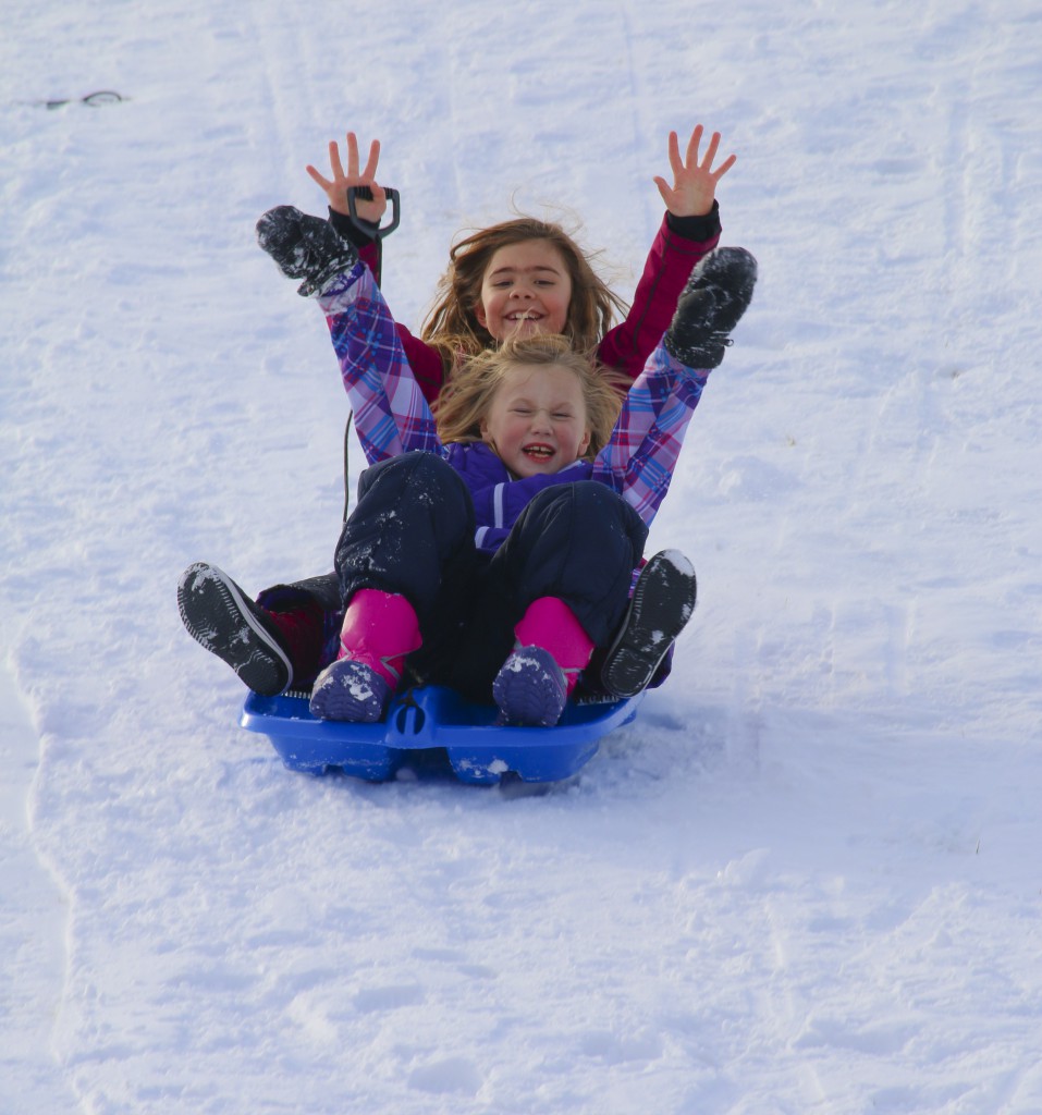Two young sledders take advantage of an early Christmas break at West Valley Jr. high after the most recent winter storm rolled through Yakima. – Photo by Bonnie Lozano