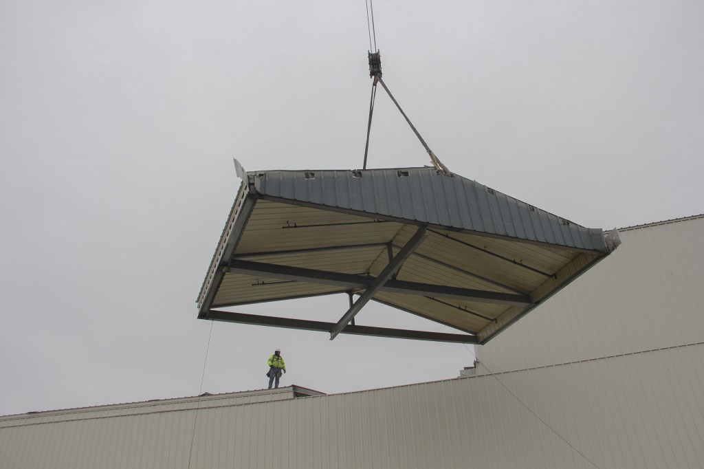  A section of the roof at Shields Bag and Printing is hoisted back in place following a large equipment install at the facility.