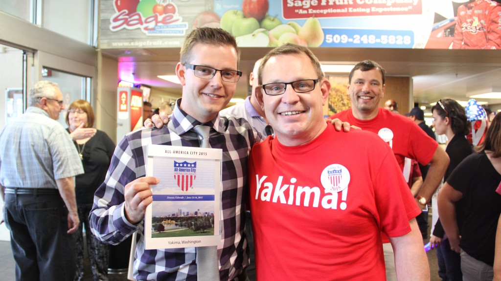 Mayor Cawley poses with and congratulates City of Yakima Communications and Public Affairs Director Randy Beehler who is holding Yakima’s 2015 All-America City Award in the Yakima Air Terminal after returning from the competition in Denver, Colorado.