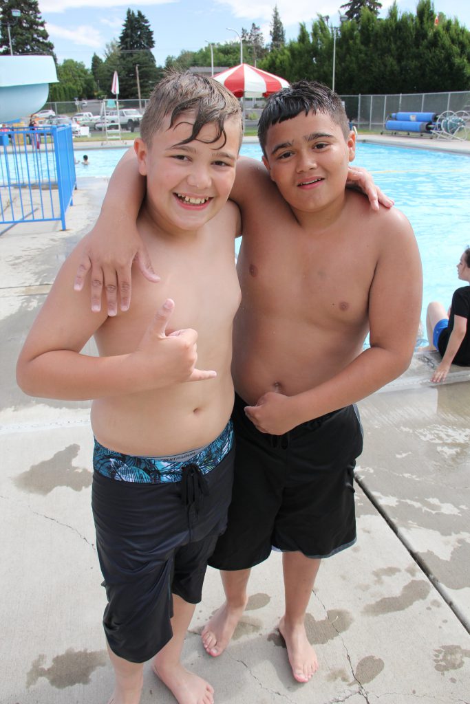 Two young swimmers take a pause from paddling to pose for a photo on opening day of the summer swim season at Yakima’s Franklin Pool. 