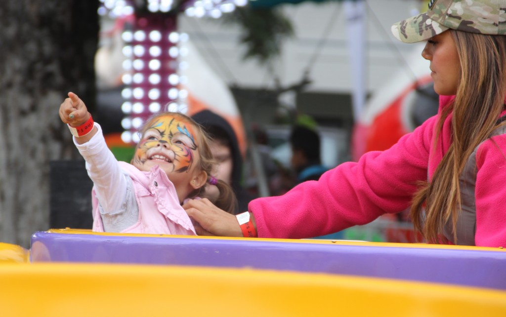 A young fairgoer points to her next ride as she takes everything in with a smile at the 2014 Central Washington State Fair.