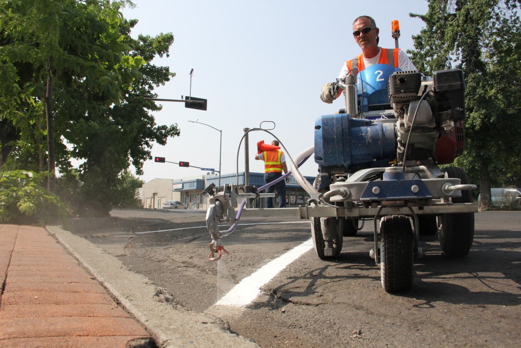 City Traffic Signs crews restripe parking in downtown Yakima as traffic rolls by in triple-digit temperatures.